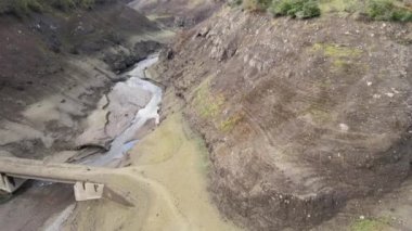 Kurumuş su deposu ve akarsu, açıkta kalan eski kütük.