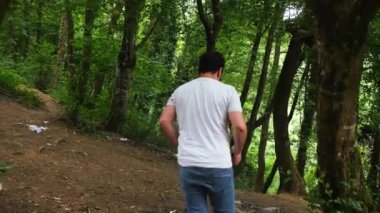 Ormanda yürüyen, ormanda ağır ağır yürüyen bir adam. kalite 4k görüntü
