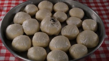 Siyah kimyon, ekmek hamuruna siyah kimyon serpiyor.