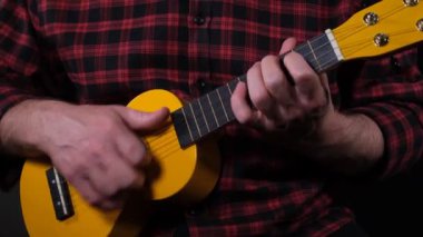 ukulele, man playing ukulele instrument close up