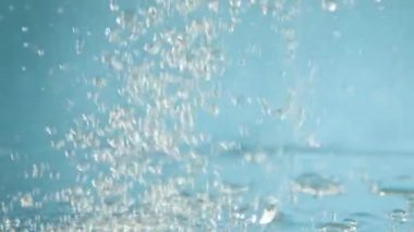 Mavi arkaplanda baloncuklar ve su kabarcıkları yavaş çekim