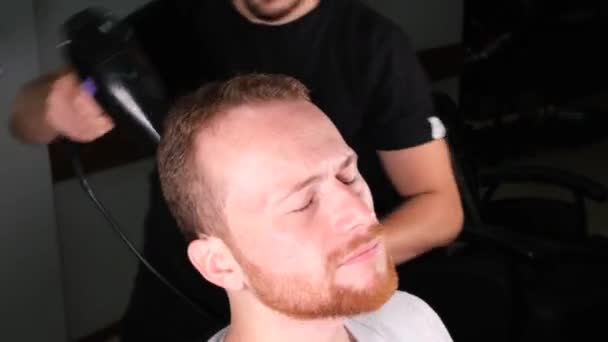 Tukang Cukur Mengeringkan Rambut Seorang Pria Berambut Merah Dengan Pengering — Stok Video