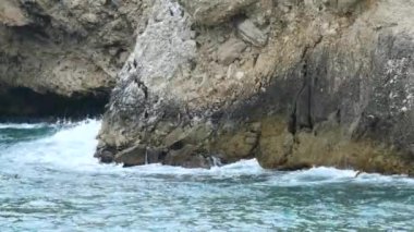 Kayalıklar, mağara yakınlarındaki kayalıklara çarpan dalgalar.