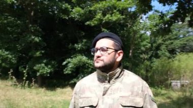 Kamuflajlı asker tarlaya bakıyor.