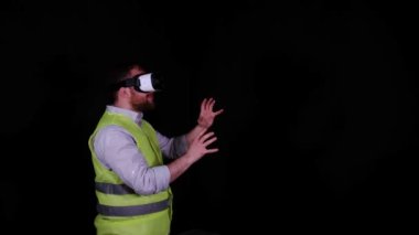 VR gözlükleri, VR gözlükleri ve iş yeleği takan adam hayali projeler çiziyor.