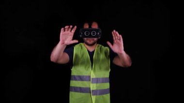 VR gözlükleri, VR gözlükleri ve iş yeleği takan adam hayali projeler çiziyor.