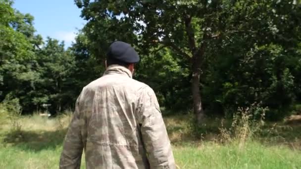 兵士が歩いている 黒いベレット兵士が野原を歩いている 高品質の4K映像 — ストック動画
