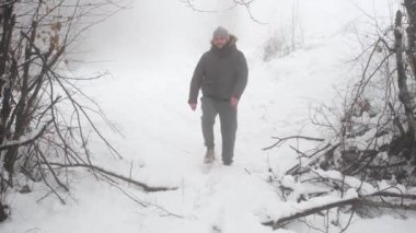 Karda yürür, adam sisli ormanda karda yürür.