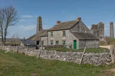 Baharın ilk günlerinde, parlak mavi gökyüzüne karşı Peak District 'te eski bir taş ev inşa etti.