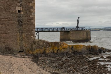 İskoç deniz kıyısında vinçli tarihi iskele.