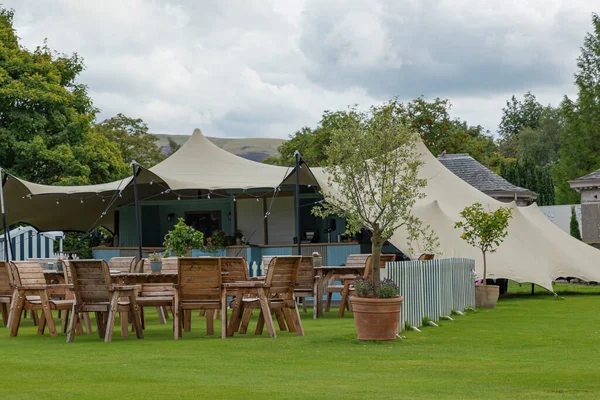 Outdoor entertainment area on the grass with a tent and a bar