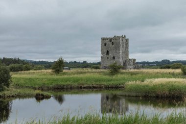 Issız bir adadaki terk edilmiş kale kasvetli gri gökyüzü ile suya yansıdı.