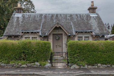 Ön kapısında çelenk olan eski bir evin ön yoluna bakıyorum.