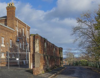 Sonbaharda büyük duvarları olan eski bir bina yan sokağa bakıyor.