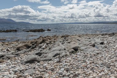 Kintyre 'da bir adaya tepeden bakan taşlık bir sahilde muhteşem bir şatafatlı kaldırım.
