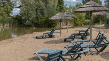 Çimen şemsiyeli ve güneş boncuklu Lakeside plajı