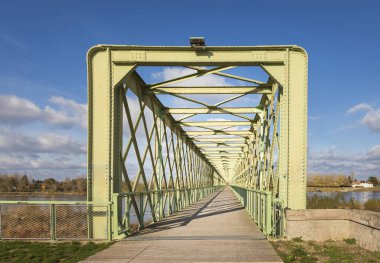 Loire Nehri 'ni açık mavi gökyüzüne karşı yeşil boyalı uzun metal bir köprü.