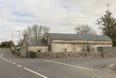 Yol kavşağının köşesindeki taş bir ahırda kadim kıvrımlı demir çatı.