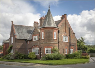 Port Sunlight, Wirral, İngiltere - 26 Temmuz 2024 Bir kulesi ve gri bir çatısı olan ev