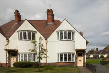 Port Sunlight, Wirral, İngiltere - 26 Temmuz 2024 Kurşunlu pencereli ve şeftali renkli kapılı iki beyaz ev