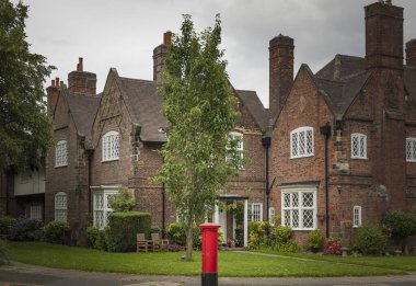 Port Sunlight, Wirral, İngiltere - 26 Temmuz 2024 - Elmas şekilli kurşun pencereli kırmızı tuğlalı evler ve İngiltere 'nin geleneksel posta kutusu