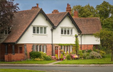 Port Sunlight, Wirral, İngiltere - 26 Temmuz 2024 Kum taşı ve kırmızı tuğlalı beyaz ev