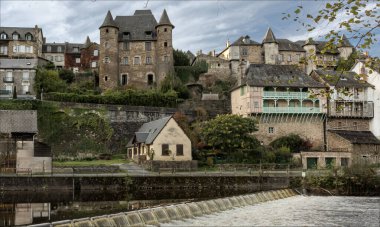 Uzerche, Coreze, Nouvelle-Aquataine, France - November 8th 2024 - Historic fortified town with history dating back to Roman times above a river with a weir across clipart