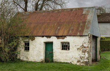 Ballymore, İrlanda Cumhuriyeti - 14 Mart 2024 - Eski ve geleneksel beyaz boyanmış İrlanda gecekondu binası terk edilmiş