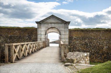 İrlanda Cumhuriyeti - 15 Mart 2024 - Deniz kıyısındaki taş bir kemer boyunca tahta bir geçide bakın