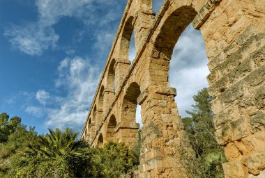 Tarragona, Spain - December 24th 2024 - The ancient Roman aquaduct of Ferreres looking upwards at the arches which support the highest part of the construction  clipart