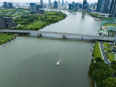 Bir tekne köprünün yakınındaki bir nehirde seyahat ediyor. Köprü büyük bir su kütlesinin üzerindedir.