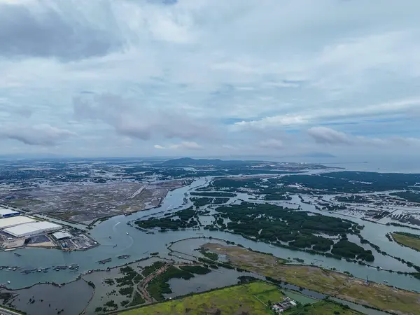 İçinden nehir akan bir şehir manzarası. Nehir teknelerle dolu ve gökyüzü bulutlu.