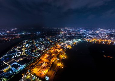 Geceleri ışıkları açık bir şehir. Şehir birçok ışıkla aydınlanıyor. Gökyüzü bulutlu.