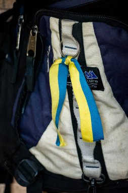 Ukrayna bayrağı renginde vatansever sarı-mavi kurdeleler bir turist sırt çantasına bağlıdır.