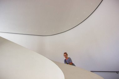 Genç kız, sarışın, gülümseyen, çizgili, tişört, bandana, çanta, poz, merdivenler, beyaz duvarlar, tam boy, uçuş, tasarım, modern, sıva, manken, gezi, kadın, müze