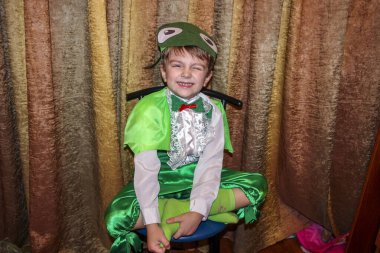 Oğlan, 6 yaşında, oyuncu, çekirge kostümü içinde, büyük gözlü bir maske, beyaz dantel kurbağa, yeşil pantolon, yağmurluk, akıllı, anaokulu, tatil, performans
