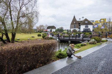Paltolu kadın, besin, su sıçanı besliyor, özel yiyecekler yiyor, kemirgenler, nehir, yol, süs bitkileri, orijinal evler, ahşap köprüdeki insanlar, bulutlu, sonbahar, hayvan, ilginç, serin, eğlence parkı, seyahat, mimari, turizm, Avrupa, manzara