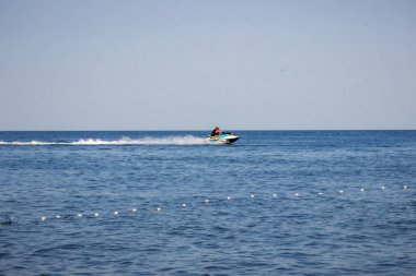 Şişme bir teknedeki insanlar, denizde iki jet ski, turistler, yüzme, dinlenme, tatil, seyahat, yaz, okyanus, gökyüzü, bulutlar, tekne