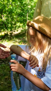 Sarışın kız, 6 yaşında, yaz şapkalı, elinde uğur böceği, elinde, ormanda, beyaz saçlı, yürüyen, böcek, aile, seyahat, turist, yeşillik, açık hava, park, doğa, güzellik.