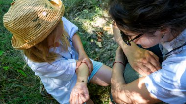 Sarışın kız, 6 yaşında, yaz şapkalı, elinde uğur böceği, annesiyle birlikte ormanda, yürüyüş, böcek, aile, seyahat, turistler, çocukluk, kız çocuğu, açık hava, kadın