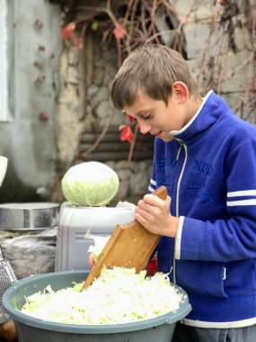 11 yaşındaki bir çocuk sonbaharda kışa lahana turşusu hazırlar.