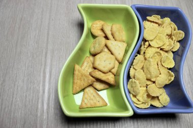 there are cookies and muesli on colored plates .