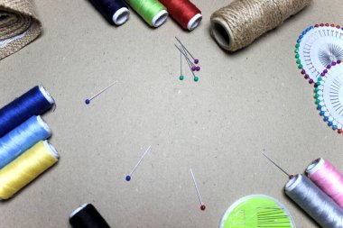 Renkli iğneler ve dikiş iplikleriyle el yapımı gri arkaplan