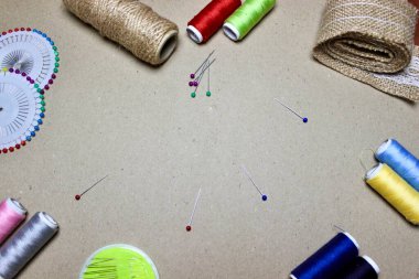 Renkli iğneler ve dikiş iplikleriyle el yapımı gri arkaplan