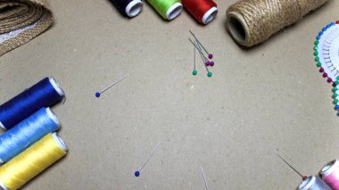 Renkli iğneler ve dikiş iplikleriyle el yapımı gri arkaplan