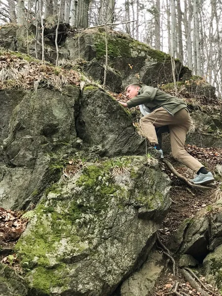 一个成年男孩热切地 热切地爬上了岩石 — 图库照片