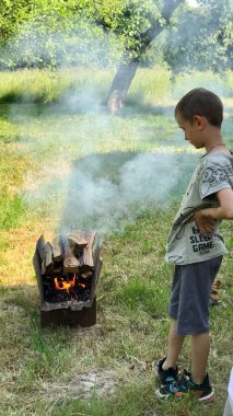 Bahçedeki köyde tatilde olan iki çocuk barbeküye yakın dinleniyor.