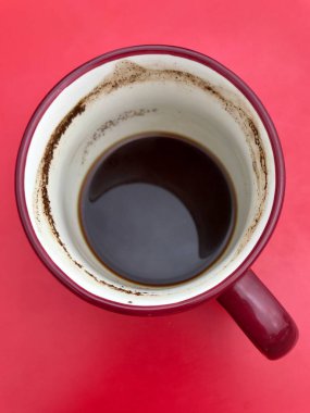 Altında pembe bir zemin olan bir kupa dolusu sarhoş kahve.