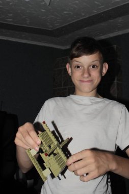 Evinde kağıt oynayan bir adam, akşamleyin, kendini oyuna kaptırır, yerde bir inşaatçıyla oynar ve onu bir paspasın üzerine monte eder.