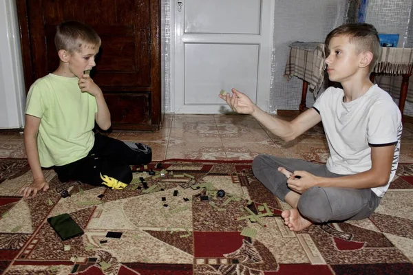 Stock image a man playing cards at home,in the evening, the boy is engrossed in the game, playing and assembling a constructor on a mat on the floor